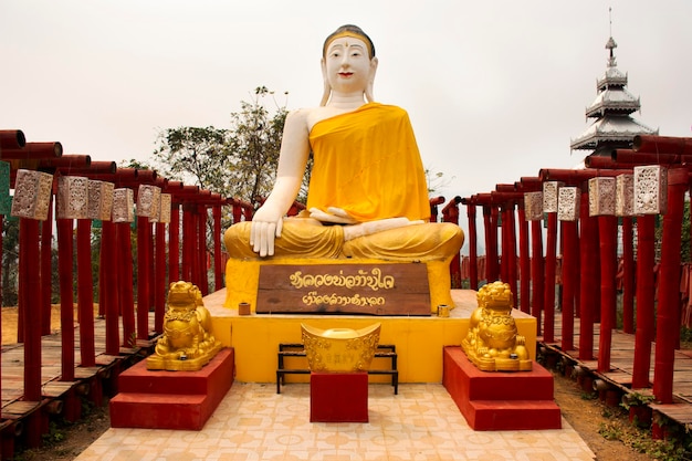 Photo big buddha statue and red torii in wat phu sa ma temple with su tong pae bridge for thai people and foreign travelers travel visit praying at pai city on february 28 2020 in mae hong son thailand