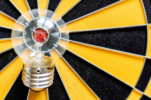 Photo big bulb target on bullseye with dartboard background