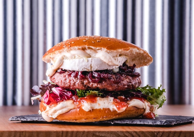 Big burger with goat cheese and tomato jam ready to eat Fastfood concept