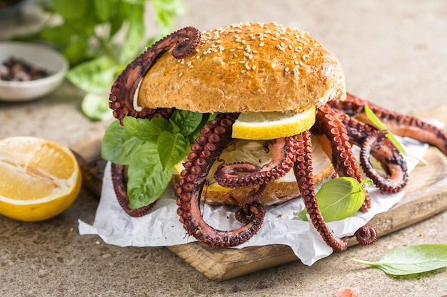 Big burger with octopus and lemon Large sandwich stuffed with seafood American fast food concept