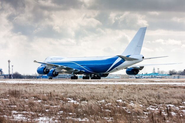 Big cargo aircraft moves on the runway at a cold winter airport