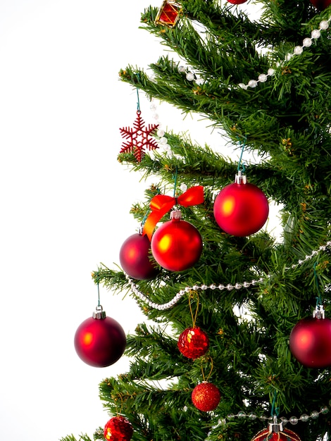 Фото Празднование празднует большая рождественская елка, украшенная звездами и красивыми красными шарами.