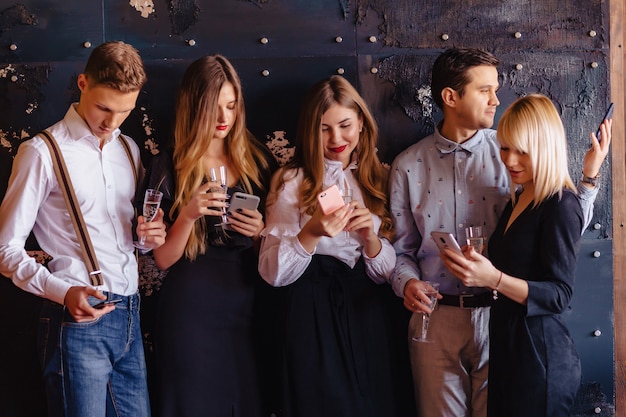 Big company celebrates a new year with glasses of champagne with phones mania