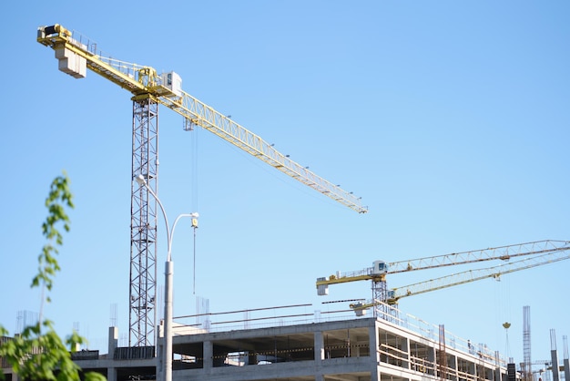 Big construction site include several cranes working on building complex