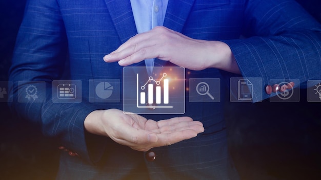 Big data analytics and business intelligence BI concept with chart and graph icons on digital screen interface and business people in the background