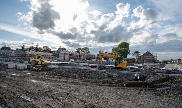 Photo big development of timber frame houses with some heavy machinery in front