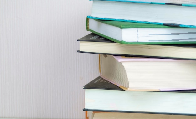 a big dog is lying on the bed with a cup, a stack of books is lying on a white background,