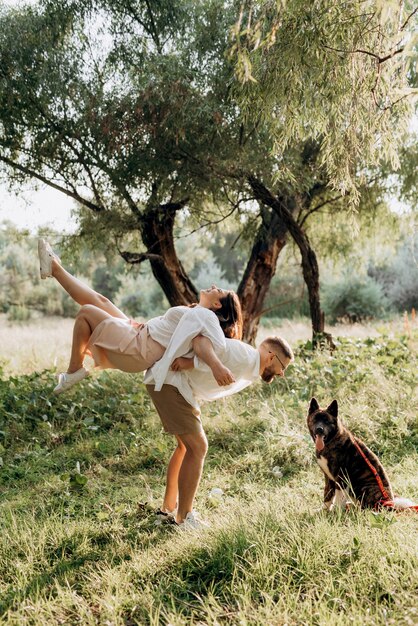 Big dog for a walk with a guy and a girl on the green prairie