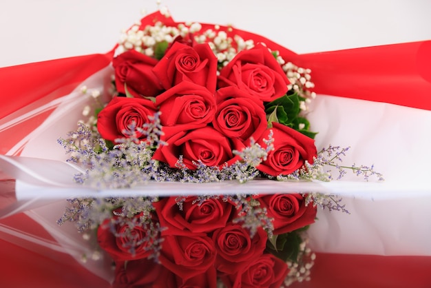 Foto un bouquet di grande eleganza e lusso composto da rose rosse con riflesso sul pavimento