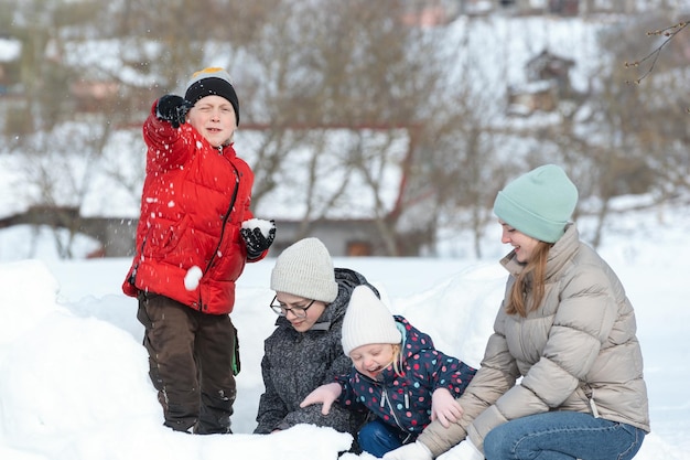 Big family are playing in snowballs Active outdoors leisure with family with children in winter Winter holidays