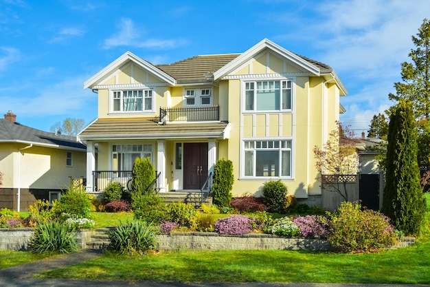 Big family house with landscaped front yard terrace on blue sky background