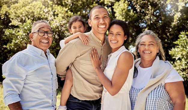 Big family hug and portrait smile in nature for fun quality bonding time in summer vacation in the outdoors Mother father and kid with grandparents smiling together in joy for family trip or park