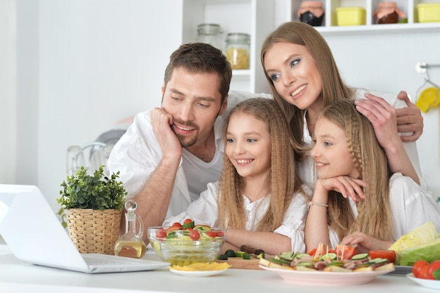 Big family on the kitchen, watching something on laptop