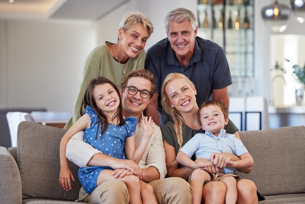 Big family love and smile of children parents and grandparent sharing a bond and support while sitting on sofa at home Portrait happiness and multi generation men and woman spending time together