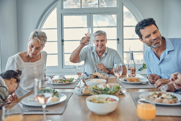 Big family lunch and happy celebration toast with grandparents parents and kid together in home Food communication and cheers of grandfather at dining table with young and senior people