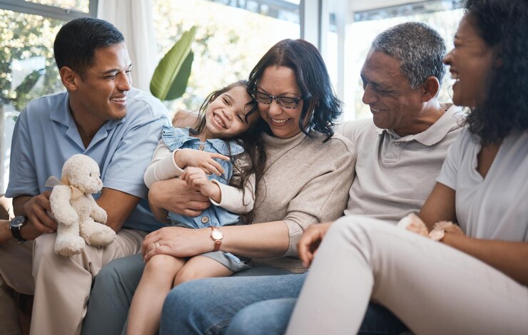 Photo big family parents and girl with teddy bear on sofa grandparents and tickle for game in home living room men women and female child with toys love and bonding on lounge couch in house on holiday