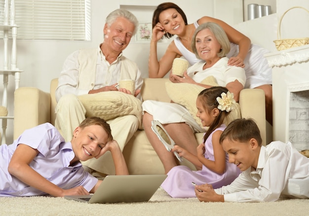 Большая семья позирует в домашнем интерьере, мама, бабушка и дедушка и дети