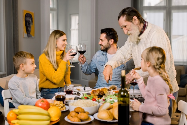 Big family with children having delicious thanksgiving dinner together at home