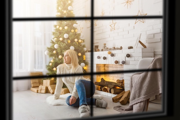 Big family with three children celebrating Christmas at home. Festive dinner at fireplace and Xmas tree. Parent and kids eating at fire place in decorated room. Child lighting advent wreath candle.