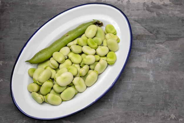 Big fresh green beans in big white dish on ceramic