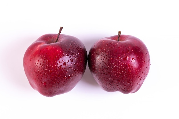 Большие свежие красные яблоки на белом фоне
