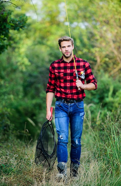 Foto pesca d'altura pescatore tenere rete da pesca hobby uomo camicia a scacchi sul ranch pescatore con canna da pesca uomo in cappello da cowboy ritratto occidentale stile vintage uomo wild west retrò cowboy pesca a mosca