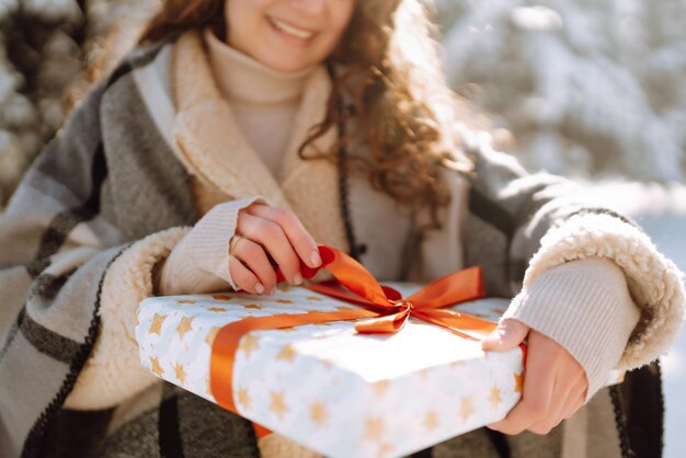 Big gift box with red ribbon in the woman hands fashion young\
woman holding a christmas present