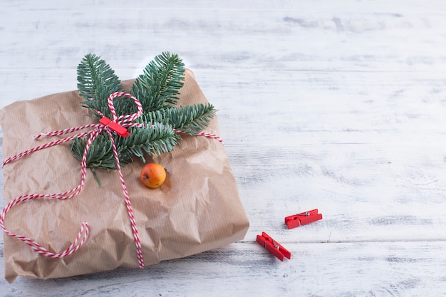 a big gift in gray paper tied with a rope, on a blue wooden 