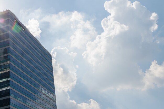 Big glass office building with blue sky and white cloud