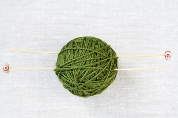 The big green skein of yarn for knitting wooden needles