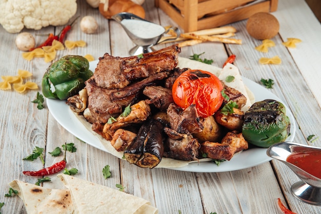 Big grilled barbecue platter meat and vegetables