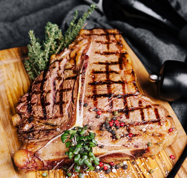 A big grilled steak on a wooden plate