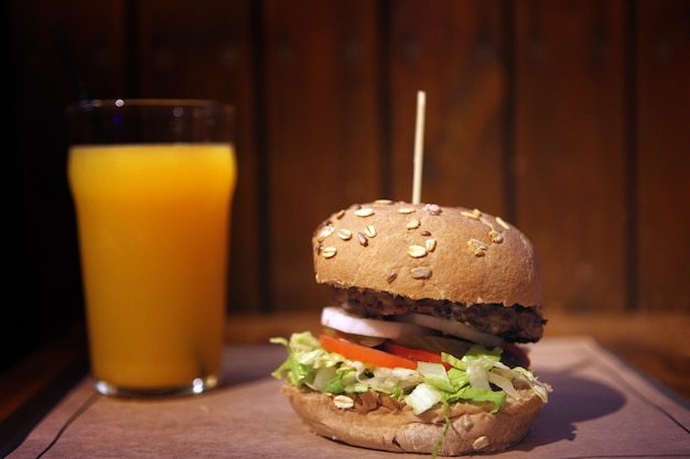 Big homemade burger with grilled meat and orange juice.  tasty burger lunch with beef. Lunch food.