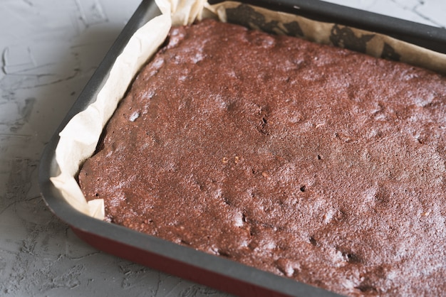 Big homemade chocolate brownie cake baked in a metal pan