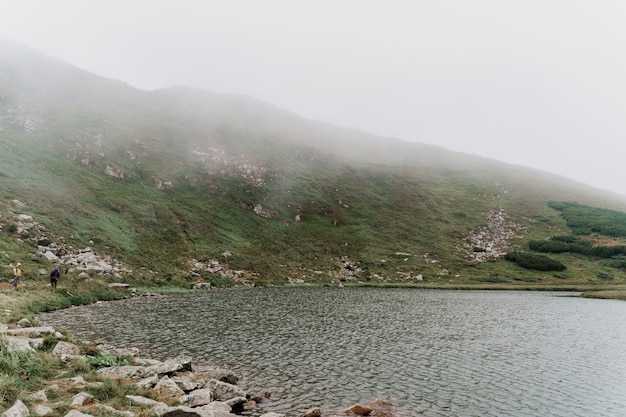 Grande lago e rocce in una giornata nebbiosa