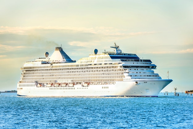 Big luxury cruise ship on the blue sea at sunset