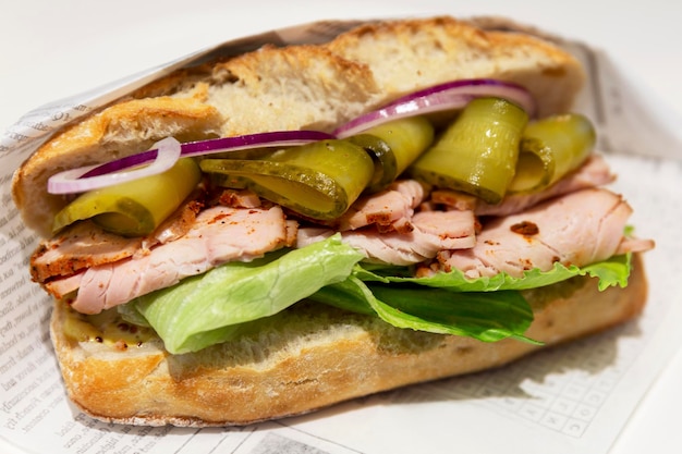 Big mouth-watering sandwich with smoked meat, vegetables and herbs. Delicious fast food. Close-up.