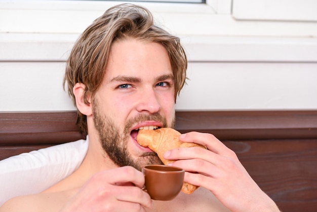 Big naked muscular man having fun in bedroom Pleasant beginning of day Handsome young man