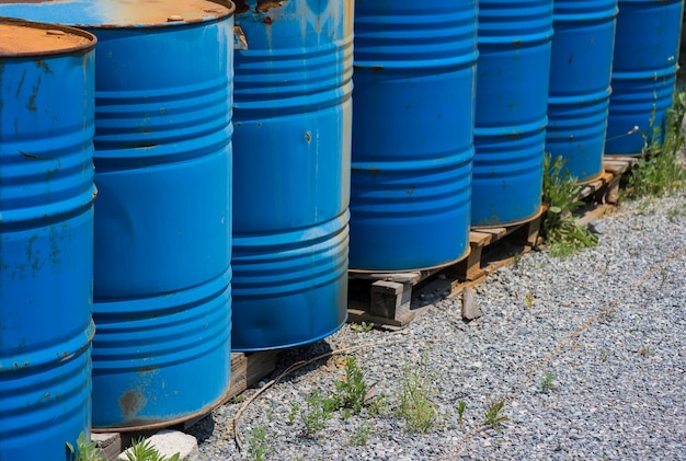 Grandi tamburi di petrolio, blu. barili chimici in un magazzino aperto.