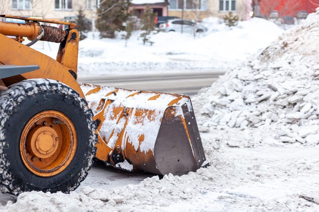 大きなオレンジ色のトラクターが道路から雪をきれいにします市内の道路の掃除と掃除