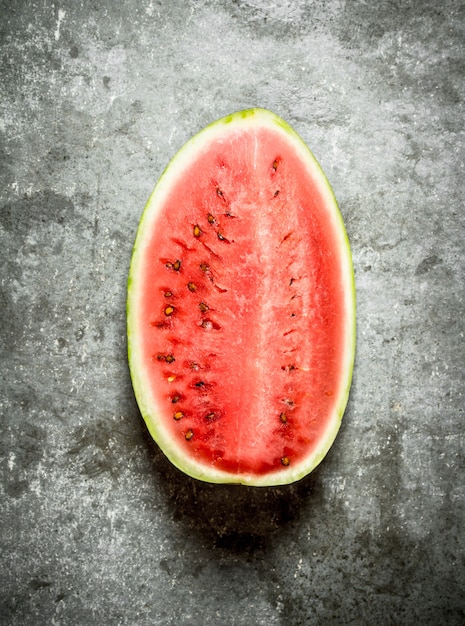 Big piece of ripe watermelon on stone table.