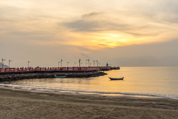 写真 日没時の海の大きな桟橋とタイのボート