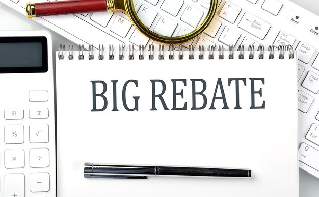 BIG REBATE Text on notepad with calculator and keyboard,business concept