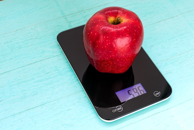 Big red apple on the scales