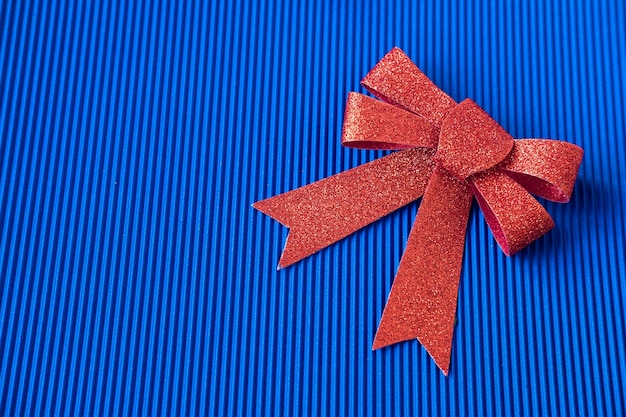 Photo big red bow on a blue background top view copy space