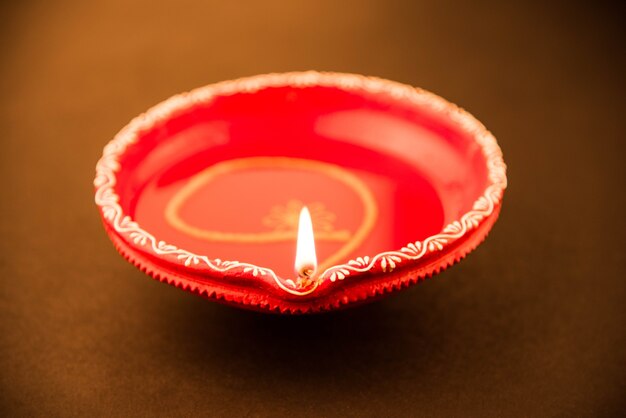 Big red decorative Clay diya or Oil Lamp lit during diwali festival. Selective focus