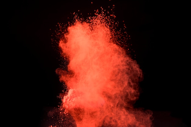 Photo big red explosion of powder on dark background