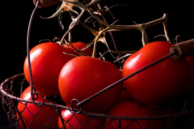 Большие красные помидоры на черном фоне
