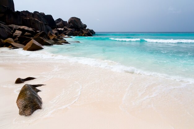 Big rocks on the beach with sand and waves