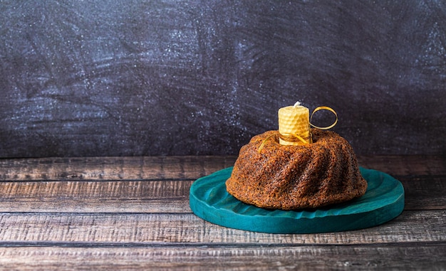 A big round cupcake on dark background with yellow candle space for textxA